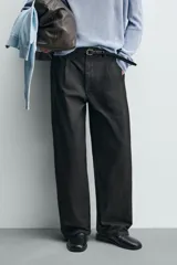 Pantalón de corte wide fit confeccionado en algodón con efecto lavado. Presenta pliegues frontales, bolsillos laterales y bolsillos traseros de vivo. Cierre frontal con cremallera y gancho metálico oculto.