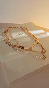Set de collares dorados con diferentes tipos de cadenas y un par de aros pequeños.