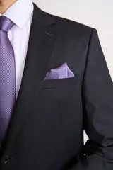 Traje de dos piezas compuesto por saco de corte clásico con cierre de un botón y pantalón de vestir a juego. Presenta solapas de muesca y bolsillos con solapa.