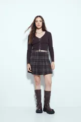 Top de tejido acanalado color negro, con escote en V y cierre frontal mediante cordones ajustables con ojales metálicos. Presenta mangas largas y un corte entallado al cuerpo.