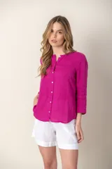 Camisa de lino color fucsia, con cuello mao y cierre frontal con botones. Presenta mangas tres cuartos y un corte recto y holgado.