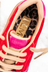 Zapatillas rojas de gamuza con detalles en rosa y suela marrón.