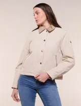 Campera acolchada capitoneada, marca Michael Kors, de color beige con cuello camisero de gamuza en contraste. Cuenta con cierre frontal de botones a presión metálicos, bolsillos laterales inclinados con ribetes de gamuza y mangas largas.