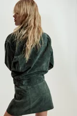 Cazadora de ante color verde oscuro, con cuello solapa, cierre frontal con cremallera oculta y botones a presión, bolsillos laterales con cremallera, manga larga con cremallera en puños y bajo elástico.