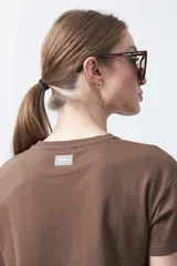 Remera negra de manga corta con estampado botánico en azul y la frase "NOTHING GROWS IN COMFORT".