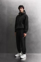 Sudadera con capucha de entrenamiento, confeccionada en tejido técnico de algodón con efecto neopreno. Presenta cierre frontal de cremallera, cuello subido, bolsillos laterales y un bolsillo en el pecho, todos con cierre de cremallera y acabado termofijado.