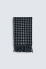 Bufanda de tejido suave con diseño de cuadros vichy en tonos gris y azul marino, terminada con flecos en los extremos.