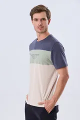 Remera de manga corta con diseño de bloques de color en tonos gris, blanco y azul marino. Cuenta con cuello redondo y una estampa tipográfica en el centro del pecho.