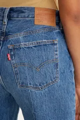 Jean de corte recto y tiro alto, confeccionado en denim de algodón con lavado azul medio y efecto desgastado.