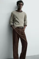 Pantalón de corte straight fit confeccionado en ante de color marrón, con diseño de cinco bolsillos y cierre frontal con cremallera y botón.
