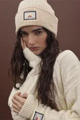 Gorro de punto fucsia con etiqueta de marca en el frente.