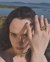 Anillo dorado con forma irregular y un agujero en el centro.