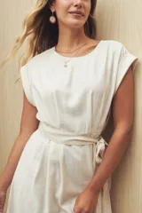 Vestido midi color beige con cuello bote y mangas cortas. Incluye cinturón de la misma tela.