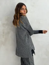 Sweater de punto acanalado color gris, con cuello polo y escote en V. Diseño holgado con mangas largas y aberturas laterales en el dobladillo.