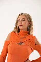 Polera naranja de mangas largas con cuello alto y abertura en el pecho.