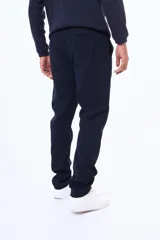 Pantalón de gabardina en color negro, de corte recto y ajuste cómodo, con cierre frontal y bolsillos laterales.