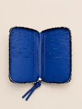 Billetera rectangular de cuero con textura de reptil, cierre perimetral y correa de muñeca lateral. Presenta un pequeño aplique metálico circular en el centro.