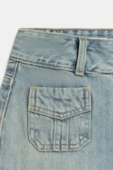 Jeans de tiro bajo con corte flare, confeccionados en denim azul con lavado localizado. Presentan bolsillos de plastrón en el frente, trabillas para cinturón y cierre frontal con cremallera y botones metálicos.
