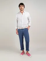 Camisa celeste a rayas verticales de lino, corte regular fit, cuello italiano, cierre con botones, manga larga terminada en puño simple y logo bordado en el pecho.