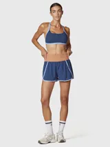 Short deportivo 2 en 1 color azul con detalles en celeste, que incluye calza interior incorporada. Presenta una cintura ancha de tiro alto en color tostado, con diseño de bordes redondeados y costuras a contratono.