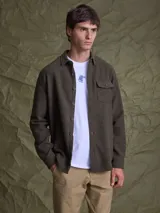 Camisa tipo overshirt de textura gruesa, color marrón, con cierre frontal de botones, cuello clásico y bolsillo frontal con solapa.