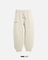 Pantalón de jogging color crema, corte holgado, con cintura elástica ajustable con cordón, puños elásticos y logo bordado en tono a tono.