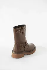 Bota de caña media confeccionada en cuero negro, con suela gruesa track antideslizante. Presenta un diseño estilo biker con estribo integrado, hebillas metálicas decorativas y una correa ajustable en la parte superior de la caña. Incluye cierre lateral para facilitar el calce.