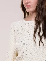 Buzo de algodón blanco con diseño de punto calado y mangas anchas.