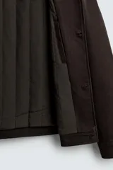 Cazadora de corte relajado confeccionada en una mezcla de lyocell y algodón con interior acolchado. Presenta cuello solapa, cierre frontal con botones, mangas largas con puños abotonados y dos bolsillos de plastrón en el pecho.