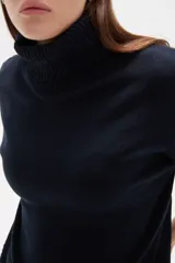 Polera de tejido de punto color gris, con cuello alto, mangas 3/4 y diseño holgado.