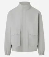 Campera gris de poliamida con cuello alto, cierre frontal oculto, mangas largas con puños elásticos y bolsillos delanteros tipo parche.