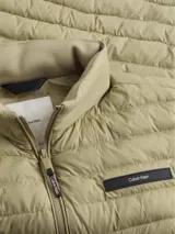 Chaleco acolchado Calvin Klein para hombre, de corte regular y cuello alto. Presenta cierre frontal de cremallera, bolsillos laterales y parche con logo de la marca en el pecho.