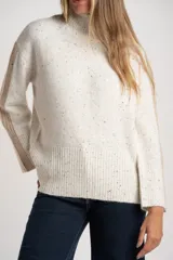 Polera de punto con diseño oversize, cuello alto y mangas largas con paneles laterales en contraste. Presenta un tejido jaspeado con motas multicolores y detalles de lurex.