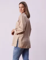 Camisola color beige de tencel, marca Hester & Orchard. Tiene cuello con solapa, escote en V, abertura central con botones y bolsillos delanteros.