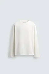 Camiseta de manga larga con corte relajado, confeccionada en tejido de algodón de peso medio, con cuello redondo acabado en rib.