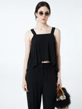 Top negro con breteles anchos y corte holgado.