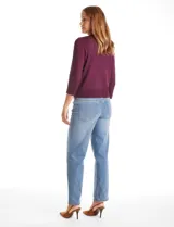 Cardigan de tejido fino con abotonadura frontal, cuello redondo y mangas tres cuartos con puños acanalados.