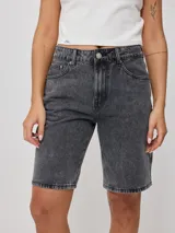 Bermuda de jean azul oscuro, corte recto y largo hasta la rodilla. Confeccionada en denim 100% algodón, con bolsillos delanteros y traseros.