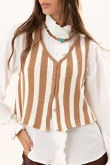 Chaleco tejido a rayas beige y blanco, con escote en V y cierre con ganchitos.