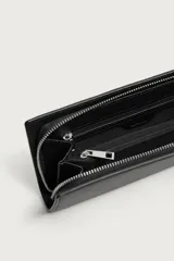 Cartera tipo bandolera de diseño rectangular con acabado grabado. Cuenta con compartimento principal con cierre de cremallera, interior organizado con dos compartimentos adicionales y asa de hombro ajustable y extraíble.