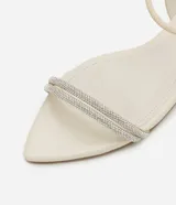 Sandalia plana color crema con punta de hoja, tira elástica en el talón y tiras dobles cubiertas de strass en la parte superior.