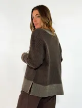 Sweater de tejido acanalado en color marrón oscuro, con cuello en V y detalles en tono metalizado en el cuello, puños y ruedo. Presenta un corte holgado y mangas largas.