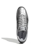 Championes urbanos Adidas modelo Barreda Lo, color plateado metalizado con las icónicas tres tiras en color negro y suela oscura. Presentan un diseño de perfil bajo con perforaciones en la puntera y cordones al tono.