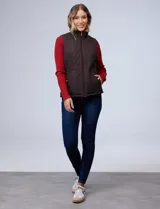 Chaleco negro capitoneado con abertura central con cierre, bolsillos delanteros con botones y forro de abrigo.