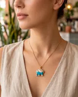 Collar de bronce con cadena fina dorada y dije en forma de elefantito esmaltado en color turquesa y blanco.