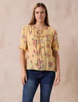 Blusa de gasa estampada con cuello a la base, escote en V plisado y lazo de ajuste. Delantera con detalles en puntilla y manga corta con puño fruncido.