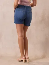 Short blanco de algodón elastizado, con pretina con pasadores, botón y cierre. Delantera con bolsillos inclinados y trasera con bolsillos simulados.