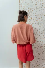 Campera estilo bomber color salmón, confeccionada en tela texturizada, con cierre frontal y bolsillos delanteros.
