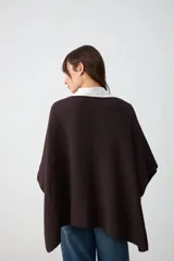 Poncho de tejido de punto con textura en color marrón oscuro, de corte holgado y diseño sin mangas.
