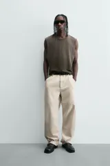 Pantalón relaxed fit color beige, confeccionado en tejido de algodón. Cuenta con bolsillos frontales, bolsillos traseros de plastrón y aplicación de bolsillos plastrón con tira multifunción en la pernera. Cierre frontal con cremallera y botón.